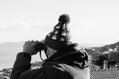 Man looking through binocular against clear sky