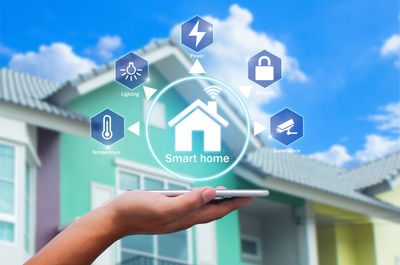 Hand holding sign board against sky