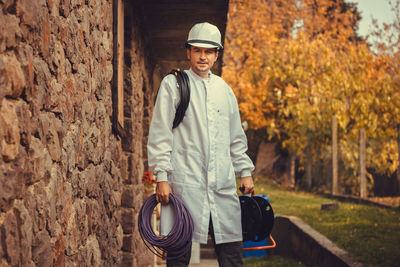 Portrait of electrician standing against trees during autumn