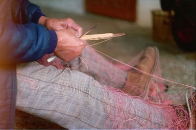 Midsection of craftsperson making thread at workshop