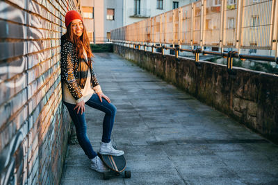 Full length portrait of woman on sidewalk in city