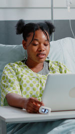 Young woman using mobile phone while sitting at home