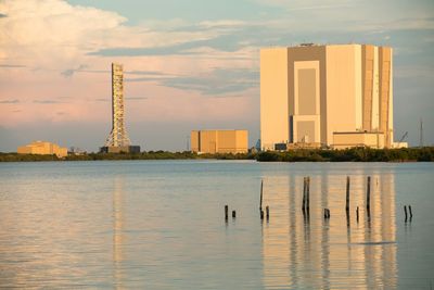 Vehicle assembly building in front of sea against sky