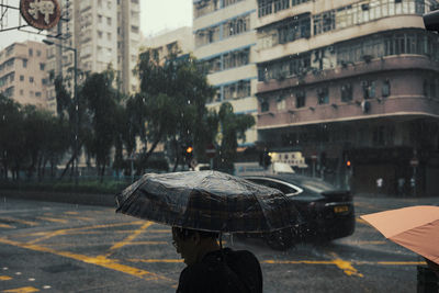Man on wet street in city during rainy season