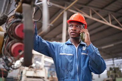 Portrait of young man standing in factory