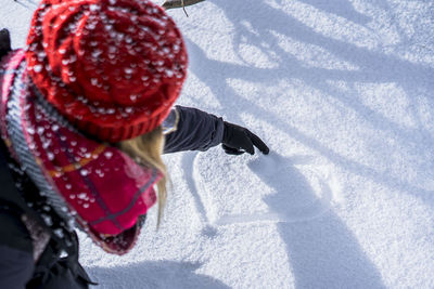 High angle view of woman making heart shape on snow