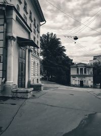 Street by buildings in city against sky