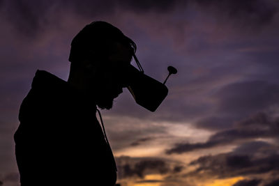 Silhouette man wearing vr goggles against sky