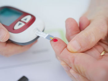 Cropped hands of female doctor examining patient at table in clinic