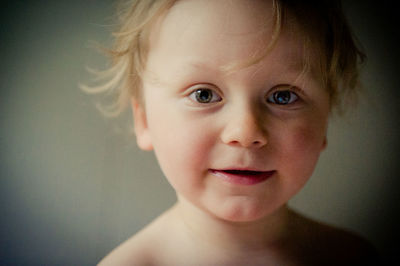 Close-up portrait of cute boy against wall