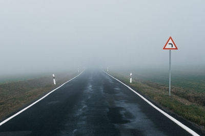 Road sign against sky