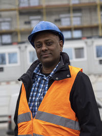 Portrait of man standing against building