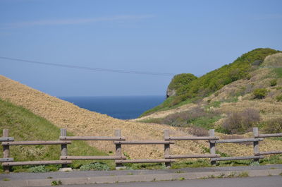 Scenic view of sea and mountains against clear blue sky