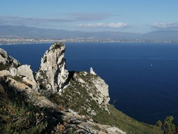 Scenic view of sea and mountains against sky