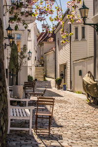 Empty chairs and tables against buildings in city