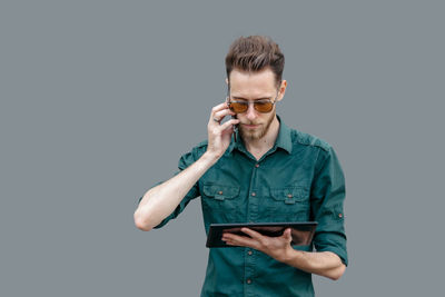 Young man using mobile phone against white background