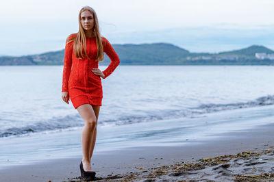 Portrait of young woman standing at beach