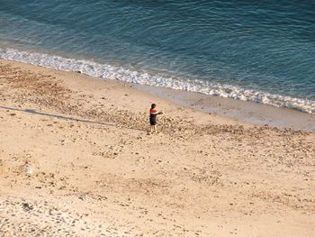 High angle view of woman standing on beach