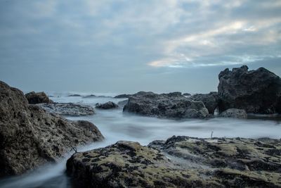 Scenic view of rocks in sea against sky