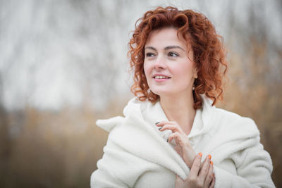 Close up portrait of attractive woman in trendy white coat