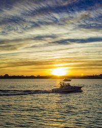 Boat sailing in sea during sunset