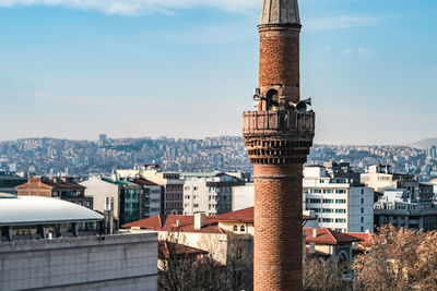 Mosque and minaret in city against sky