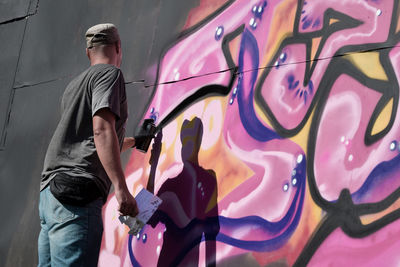 Low angle view of woman standing against wall