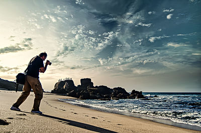 Full length of man standing on beach against sky