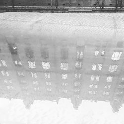 Reflection of snow on puddle on field
