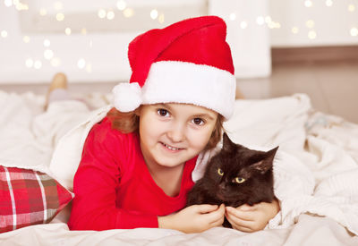 Portrait of smiling young woman with cat at home