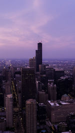 Modern buildings in city against sky during sunset