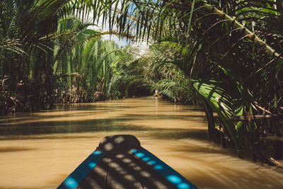 Wooden rowboat in river at forest