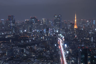 Illuminated cityscape against sky at night