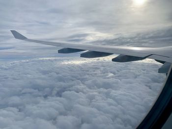 Airplane flying over cloudscape against sky