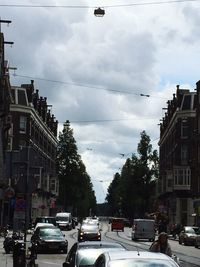 View of city street against cloudy sky