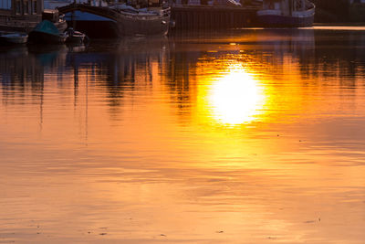 Reflection of boat in lake at sunset