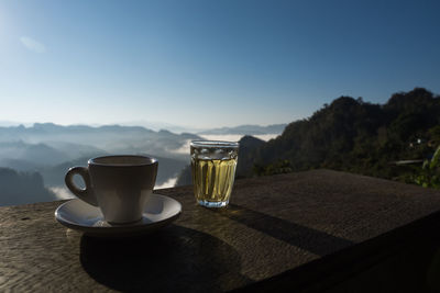 Coffee cup on table against sky