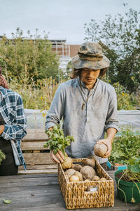 Young male environmentalist selling vegetables in farmer's market