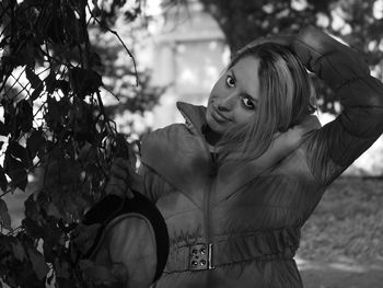 Portrait of young woman against plants