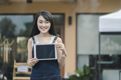 Portrait of a smiling young woman using smart phone