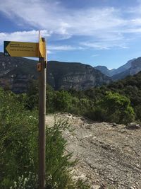 Information sign on mountain against sky