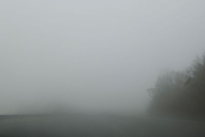 Scenic view of foggy weather against sky