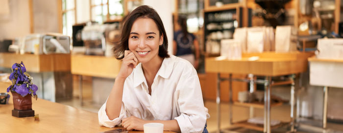 Portrait of young woman sitting at restaurant