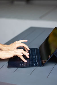 Cropped hands using laptop on table