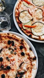 High angle view of pizza served in plates on table