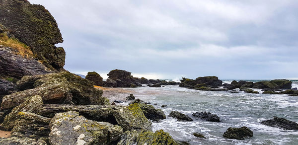 Rocks on beach against sky