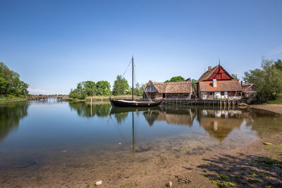 Scenic view of lake by building against blue sky