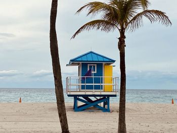 Colorful lifeguard hut on beach with palm trees 
