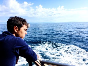 Side view of young man against sea