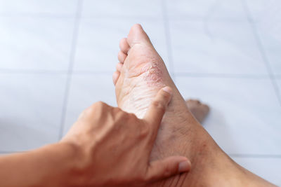 Cropped image of people hand on floor